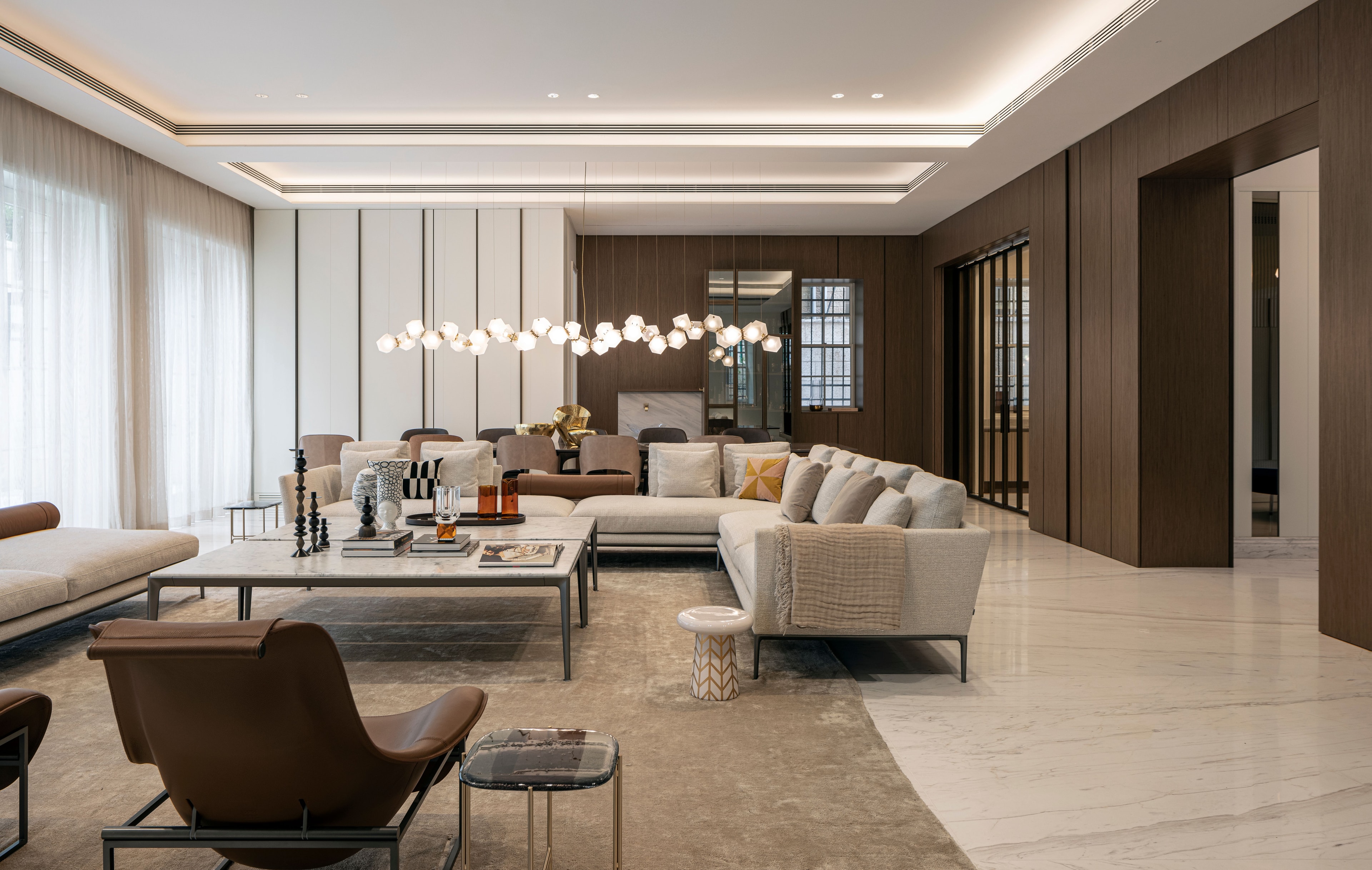 A living room and dining room with dark and light wood cladding tones. 
